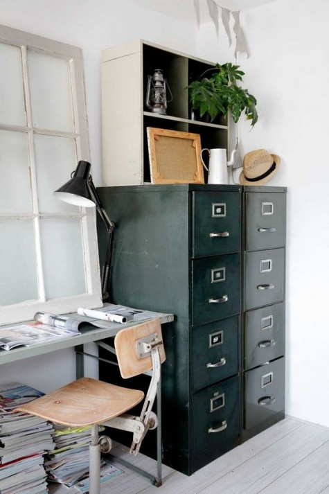 a vintage industrial home offie, a metal desk, a metal and wood chair, a metal paper cabinet and some greenery