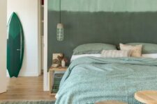 a watercolor green statement wall and green printed bedding for a relaxing and comforting feel