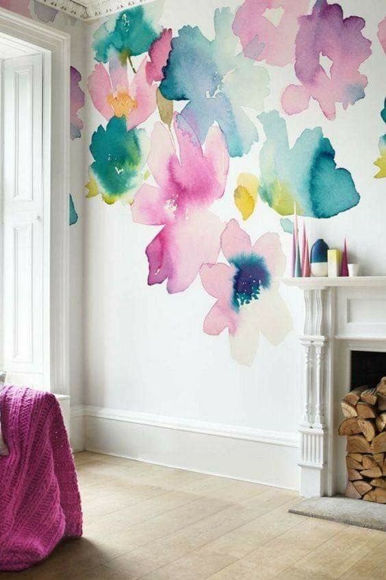 an accent wall with bright watercolor blooms all over instead of a usual artwork, it's a bold and catchy solution