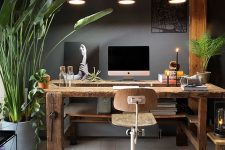an eclectic home office with grey walls, a rustic wooden desk and beams, an industrial stool and pendant lamps