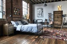 an industrial bedroom with a brick wall, a ceiling with beams, a metal bed, wooden nightstands, metal shelving units and marquee lights