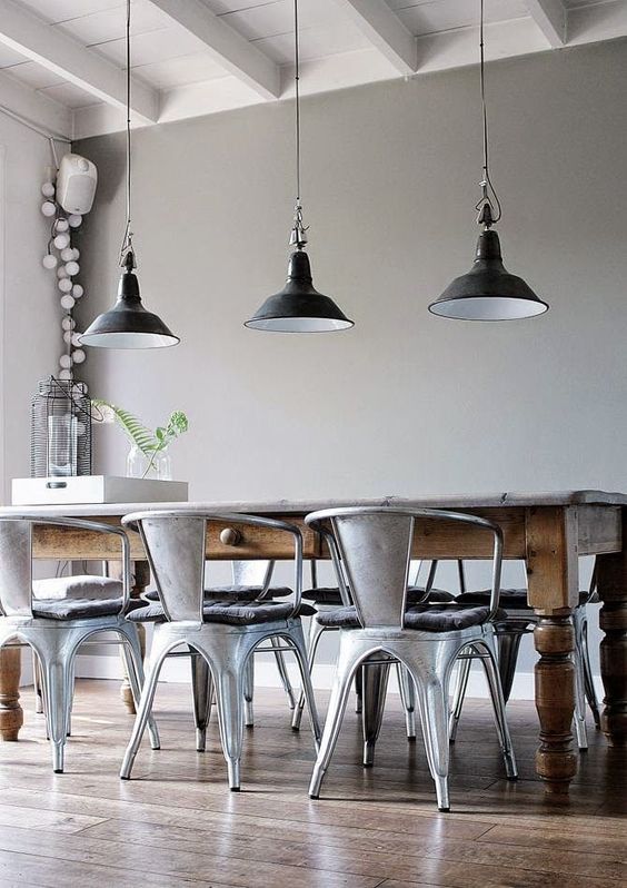 an industrial dining space with grey walls, a vintage stained table, metal chairs and black pendant lamps is a lovely idea to rock