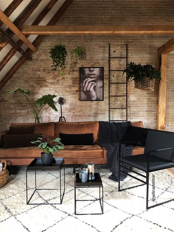 an industrial look is achieved with brick walls, metal coffee tables and a ladder