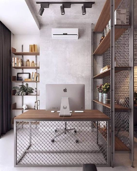 an industrial working space with a metal shelving unit as a space divider, a matching desk, built in shelves and spotlights on the ceiling