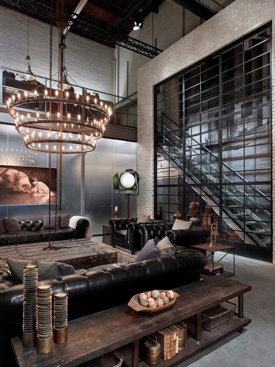wood and aged metal furniture, metal stairs, an industrial chandelier of metal and bulbs