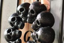 a Halloween wreath of glitter black skulls and an orange bow on top is a classic decor idea for Halloween