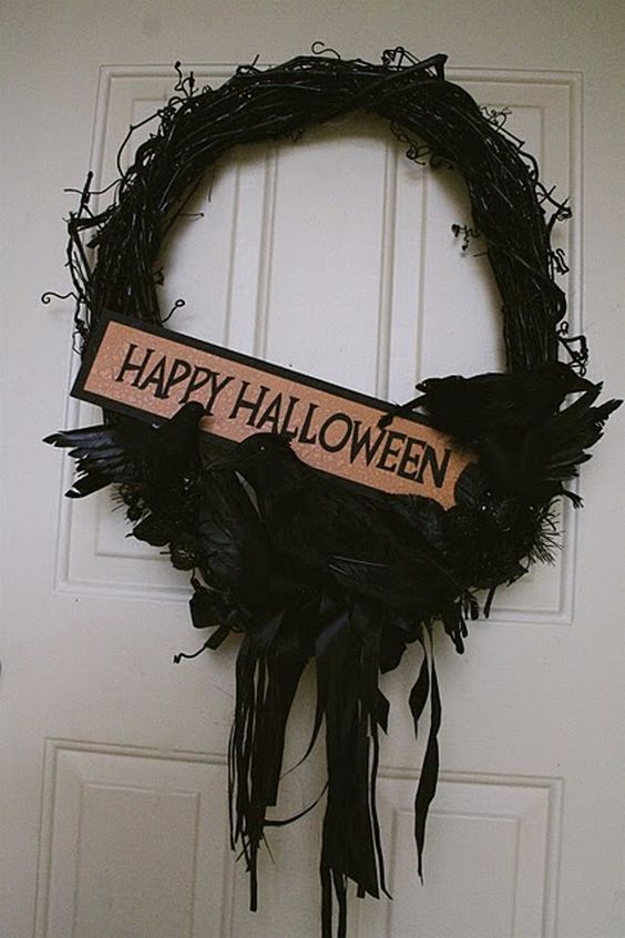 a black Halloween wreath of vine, with blackbirds, feathers and ribbons plus a mini sign is a creative and bold solution
