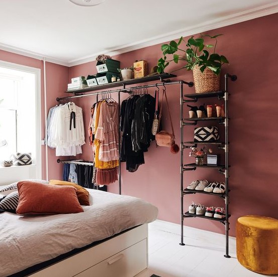 a black metal pipe shelving unit and rack suitable for both shoes and clothes and even a potted plant is a great idea