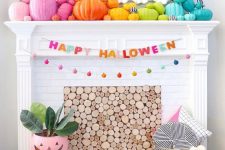 a bright Halloween mantel with bold rainbow pumpkins, a mini pumpkin garland, yarn letters and a pompom basket