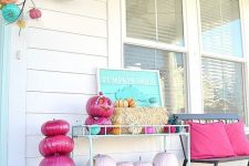 a bright and fun Halloween porch with turquoise, pink, blush pumpkins and signs and pillows