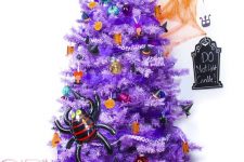 a bright purple Halloween tree with colorful ornaments and pumpkins, a witch hat and a spider is all fun