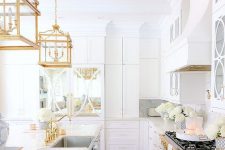 a cool white kitchen design with gold accents