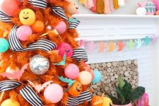 a colorful Halloween tree in orange, with pastel ornaments and balloons, striped garlands and jack-o-lanterns