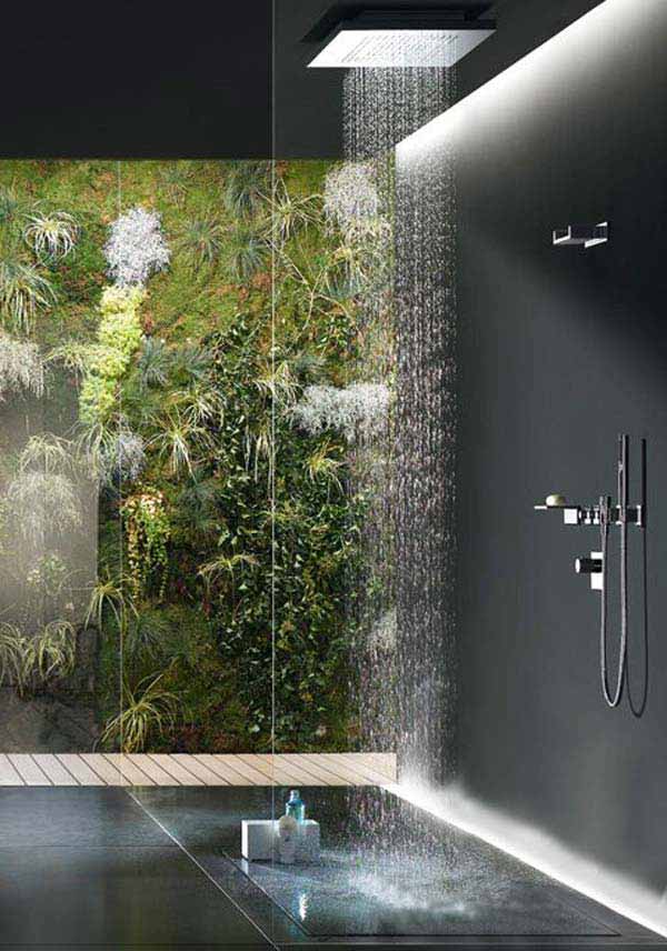 a contemporary bathroom with a glazed wall and a view of an outdoor living wall, black stone tiles and a rain shower head