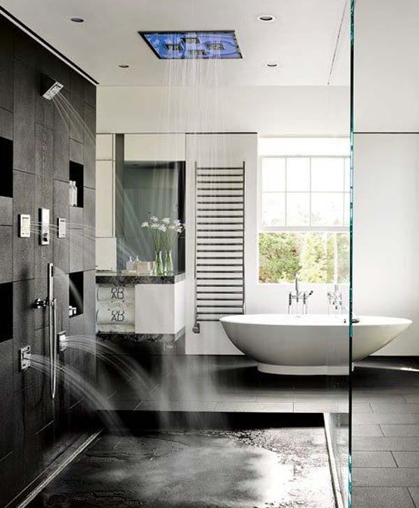 a contemporary black and white bathroom with black stone tiles, an oval tub and rain shower heads on the wall and ceiling