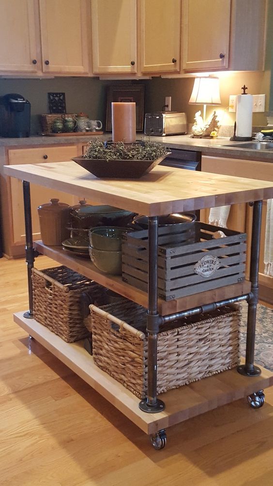 a creative industrial kitchen island on casters built of butcherblock pieces and black piping is a very functional and practical idea