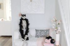 a glam Halloween entryway with a skeleton in pearls and fur, pink and black velvet pumpkins