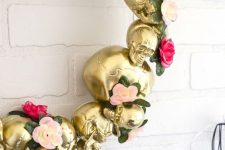 a glam Halloween wreath of gold skulls, pink and blush faux blooms and greenery is a pretty and lovely idea to rock