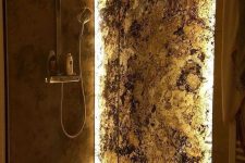 a gorgeous shower space with a lit up stone accent wall and modern fixtures plus a rain shower – this accent wall just wows