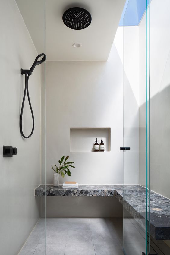 a laconic contemporary shower space with natural light and a catchy built-in stone bench plus a rain shower is amazing