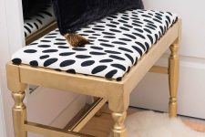 a lovely gold bench with a spotted seat, a black and gold pillow is a pretty idea for any modern glam room