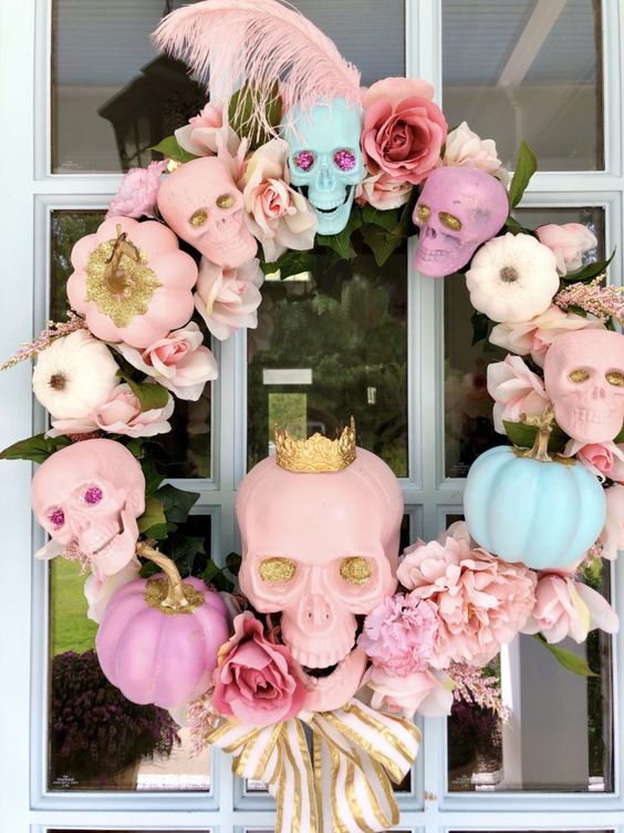 a lovely pastel skull, pumpkin and bloom wreath with feathers, ribbon bows and leaves for Halloween