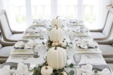 a modern Thanksgiving table with white pumpkins and eucalyptus, grey glasses and plates and all white everything