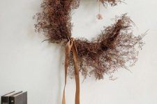 a moody rust-colored branch crescent moon wreath with rust silk ribbons is an out of the box and fresh idea for Halloween