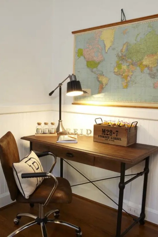a pretty and small home office with a map on the wall, a metal pipe and wood desk, a leather chair for a lovely and cozy nook