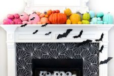 a rainbow pumpkin mantel with bats, eyeballs in the fireplace for fun and bold Halloween styling