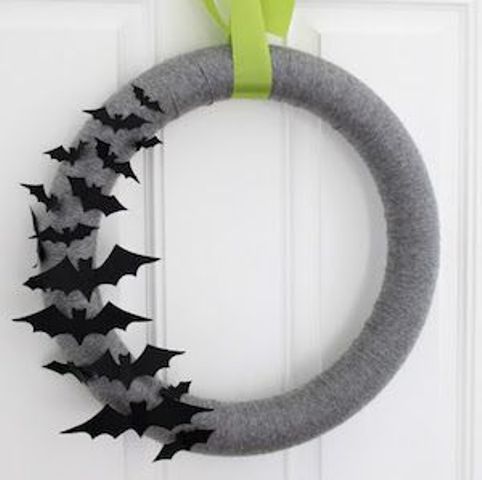 a simple and pretty grey Halloween wreath accented with black paper bats on one side is a cool solution for Halloween