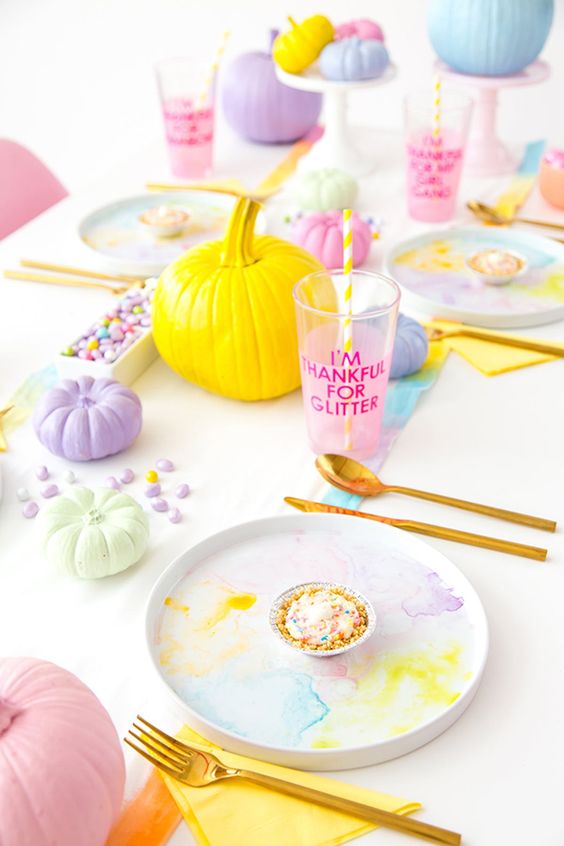 a super bold pastel Halloween tablescape with watercolor plates, pumpkins, drinks and candies
