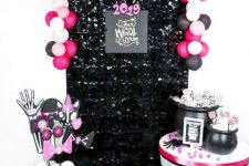 glam Halloween decor wiht a black sequin cover, pink, blush and black balloons, hot pink and purple props and a skeleton