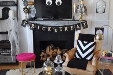 glam Halloween decor with a black banner, spiders, bats, gold skulls and a hot pink stool