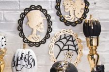 glam Halloween decor with skull portraits, a black and gold dip pumpkin, a bejeweled skull and candles