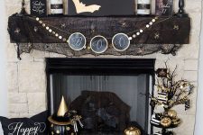 glam black and gold Halloween decor – an artwork with gold bats, a gold garland, gold candles, pumpkins and black mesh