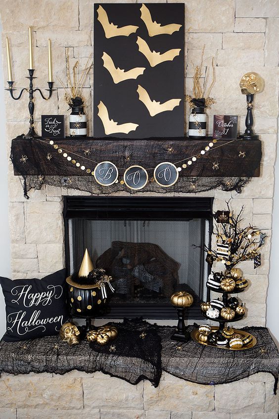 glam black and gold Halloween decor - an artwork with gold bats, a gold garland, gold candles, pumpkins and black mesh