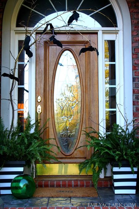a Halloween front door styled with a branch and blackbirds is a stylish idea that doesn't require much effort
