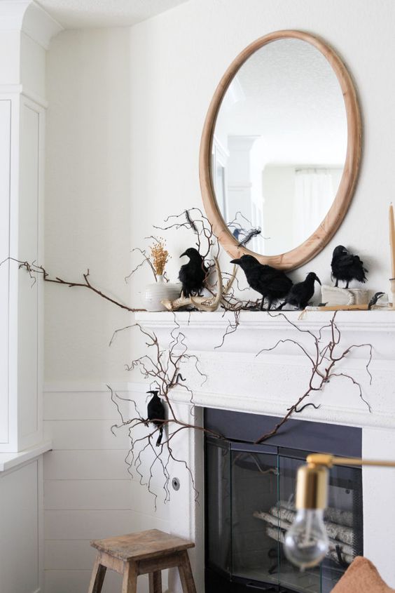 a Halloween mantel with branches, a vase with pampas grass, blackbirds and antlers is a lovely idea for Halloween
