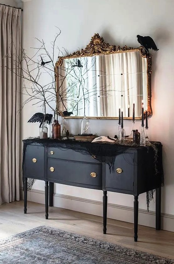 a beautiful black credenza decorated with black spider web, blackbirds, black candles and black branches is amazing