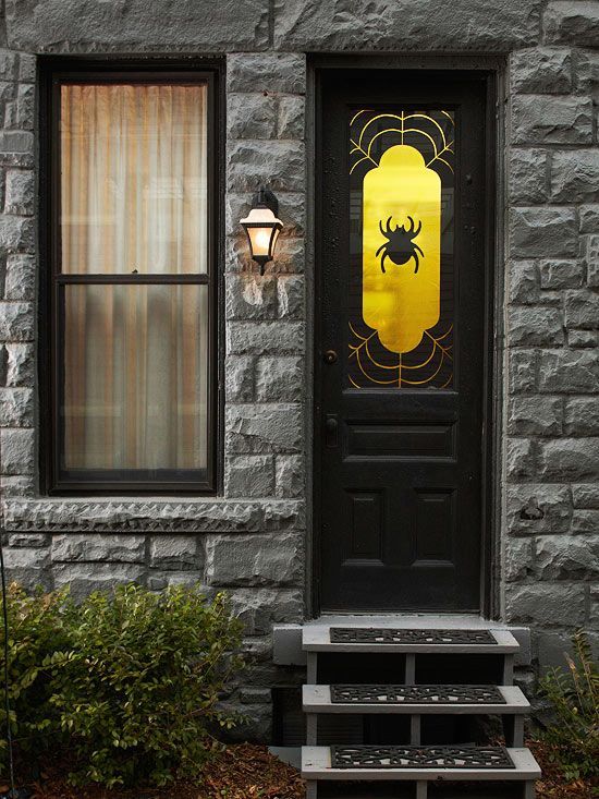 a black door styled with a gold and black decal with a spider is an easy and out of the box idea for Halloween decor