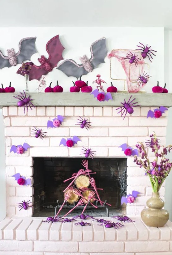 a bright and chic Halloween mantel with fuchsia velvet pumpkins, purple bats and spiders, pink skull hands and pastel bats
