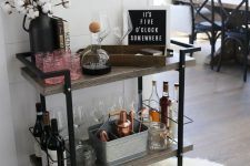a creative plywood and metal bar cart with some cotton branches, artworks, open storage compartments