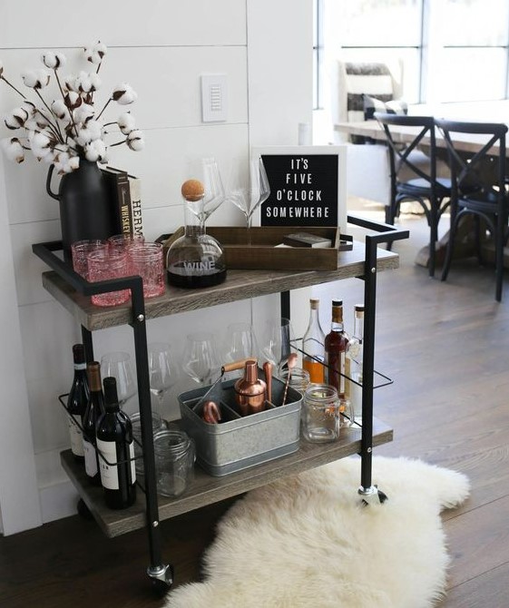 a creative plywood and metal bar cart with some cotton branches, artworks, open storage compartments