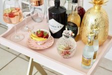 a genius IKEA hack to transform a tray table into an ultra-chic mini bar in blush is a very cute idea