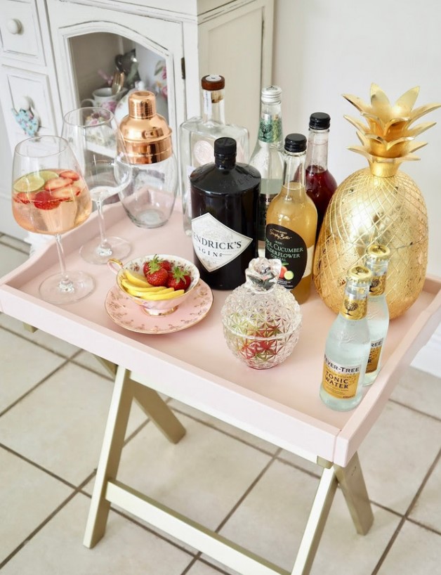 a genius IKEA hack to transform a tray table into an ultra-chic mini bar in blush is a very cute idea