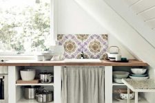 a pretty and simple neutral cottage kitchen with open storage units and butcherblock countertops, baskets and a mosaic tile mini backsplash