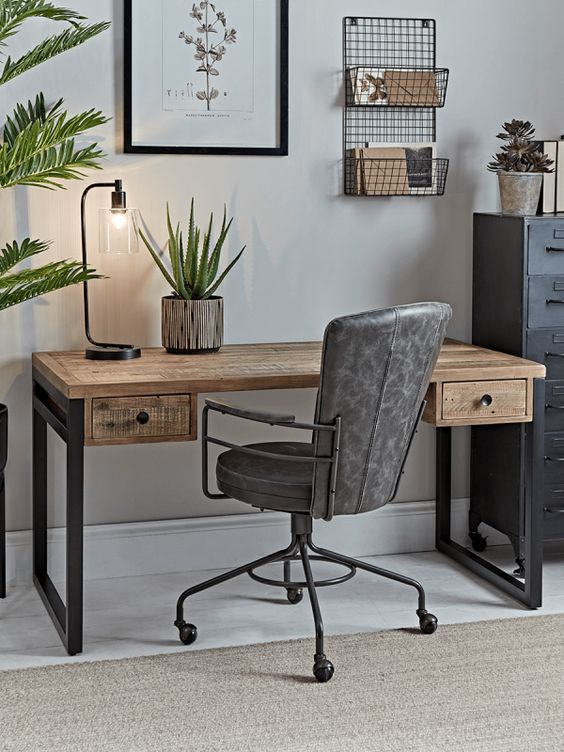 a pretty vintage industrial home office of a metal storage unit, a wood and metal desk, a leather and metal chair and some greenery