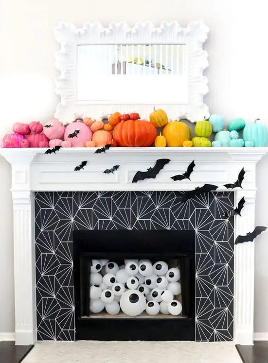 a rainbow pumpkin mantel with bats, eyeballs in the fireplace for fun and bold Halloween styling