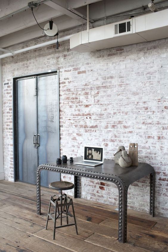 a super chic statement industrial desk of metal with an arched desktop and a vintage industrial stool is amazing
